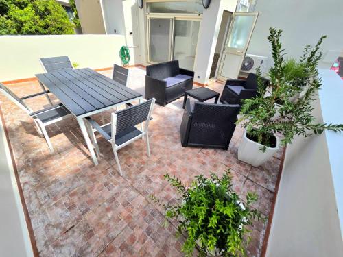 a patio with a table and chairs and plants at Civico 8 Apartment in Sassari