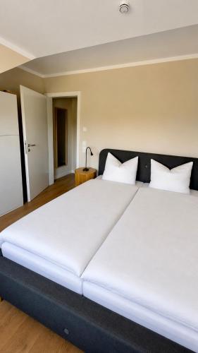 a large white bed with white pillows in a room at Haus SandRast in Westerland