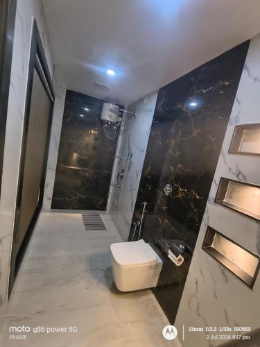 a bathroom with a toilet in the middle of a shower at Asusss International in New Digha
