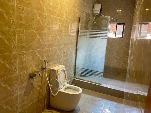 a bathroom with a toilet and a shower at Goldstep Hotel Effurun in Warri