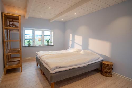 a bedroom with a bed and a book shelf at Almeboda in Österlen in Östra Hoby
