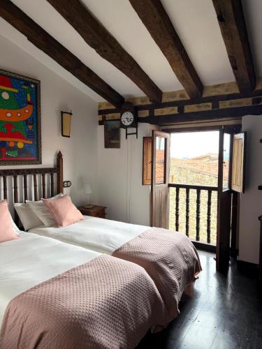 a bedroom with two beds and a clock on the wall at Museo de las Campanas, Vierna in San Bartolomé de Meruelo