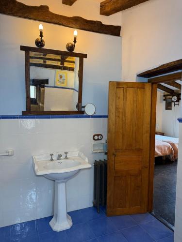 a bathroom with a sink and a mirror and a bed at Museo de las Campanas, Vierna in San Bartolomé de Meruelo