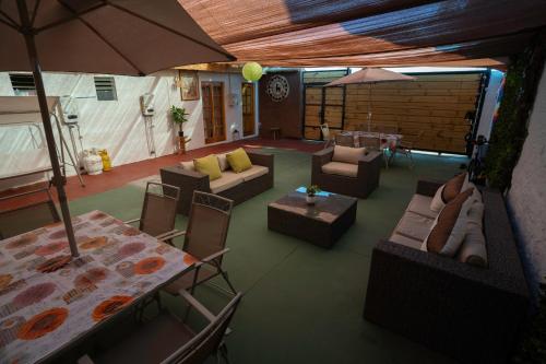 a living room with couches and tables and an umbrella at Karrizo lodge in San Pedro de Atacama