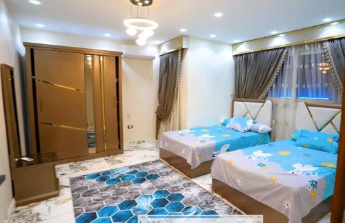 a bedroom with two beds and a glass door at Villa- Alahlam in Ghaţāţī