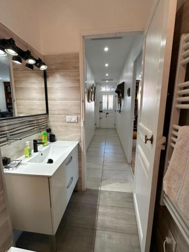 a bathroom with a white sink and a hallway at Charmante villa in Hyères