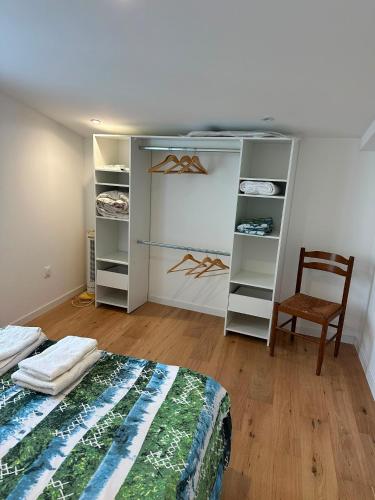a bedroom with a bed and a chair and shelves at Charmante villa in Hyères