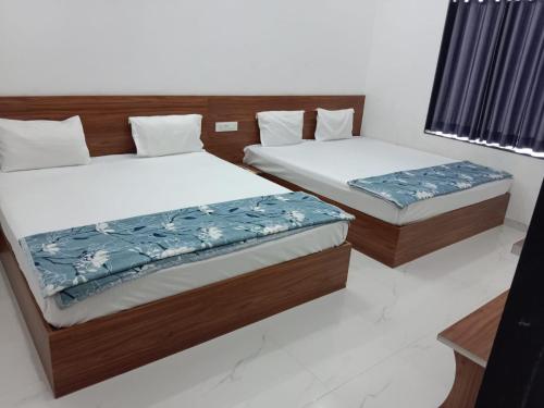 two twin beds in a room withskirts at Shree Vishwakarma place in Khātu