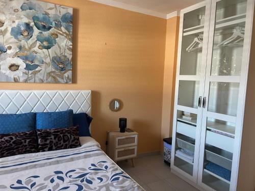 a bedroom with a bed and a painting on the wall at Habitación con baño privado in Gáldar