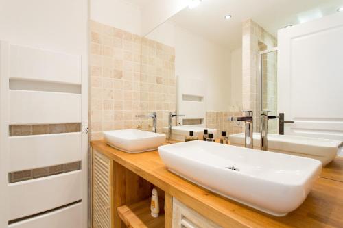 - une salle de bains avec deux lavabos sur un comptoir en bois dans l'établissement Maria Sea Cannes, à Cannes