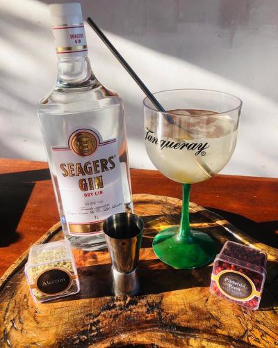 a bottle of whiskey and a glass of wine on a table at Hostel Itapiru in Mateiros
