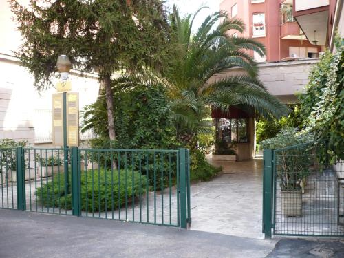 un cancello verde di fronte a un edificio alberato di Joe's Unforgettable Vatican Nest a Roma
