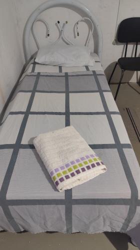 a white bed with a blanket on it at Hostel Itapiru in Mateiros