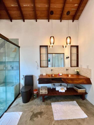 a bathroom with a large tub and a sink at Pousada Ka 347 in Itaúnas