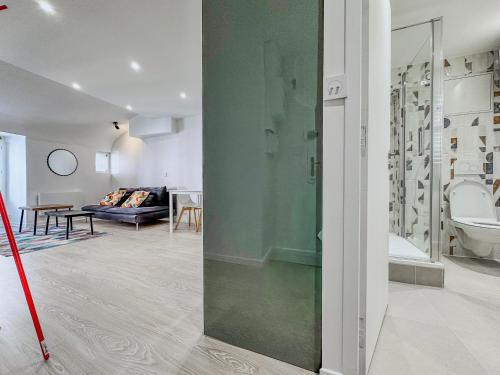 a bathroom with a shower and a living room at Le Grand Sault - Hyper-Centre in Grenoble