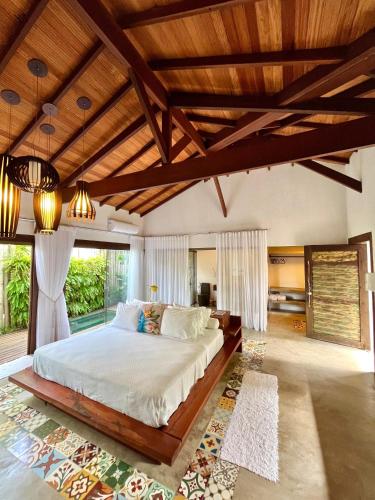 a bedroom with a large bed with a wooden ceiling at Pousada Ka 347 in Itaúnas