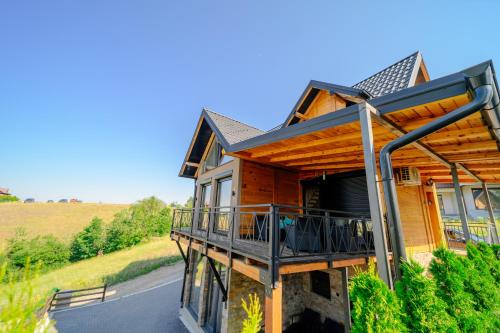 a house with a wrap around deck on a hill at LUX PINE house in Zlatibor