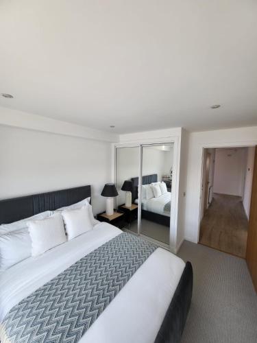 a bedroom with a large white bed and a mirror at Quayside Waters in Dundee