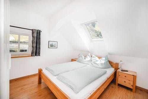 a white bedroom with a bed and a window at Haus Auszeit in Rauris