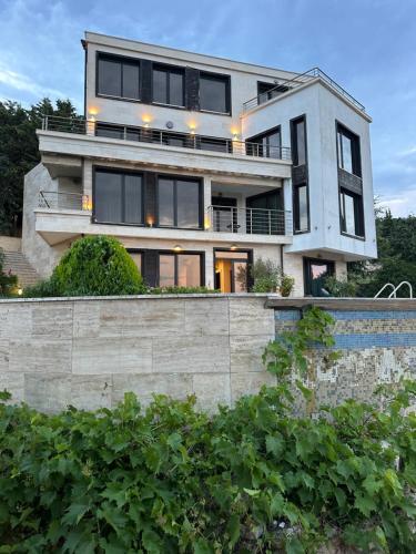 a house with black windows and a stone wall at The Shefers Residence in Rogachevo