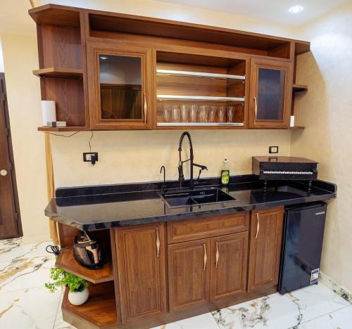 a kitchen with a sink and wooden cabinets at Villa- Alahlam in Ghaţāţī