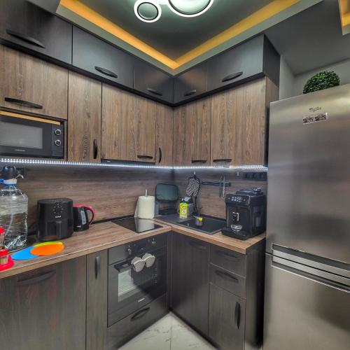 a kitchen with wooden cabinets and a stainless steel refrigerator at DN Kiten in Kiten
