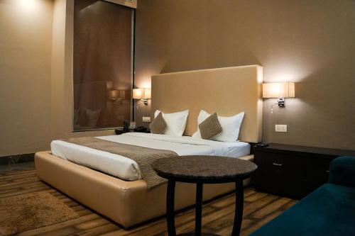 a hotel room with a bed and a table at Silver Palm Hotel & Resorts in Malaut