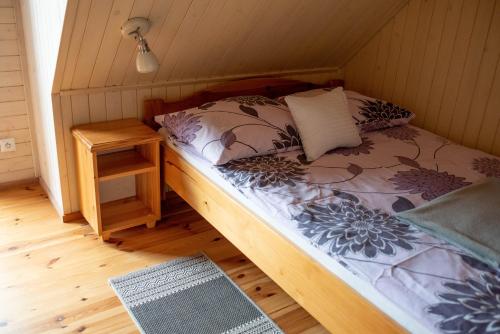 a bedroom with a bed and a night stand at Domki Pod Lasem Lubkowo in Lubkowo