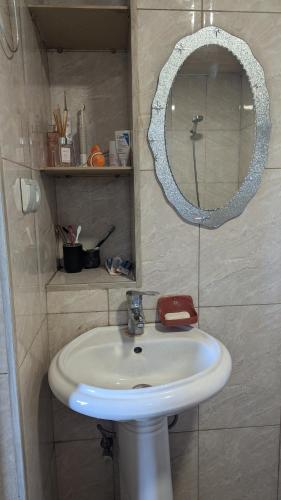 a bathroom with a white sink and a mirror at Guest house in Ipnari
