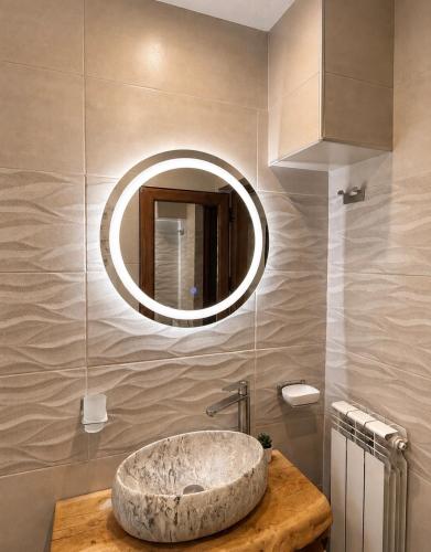 a bathroom with a large stone sink and a mirror at Krisiya's Apartment in Bansko