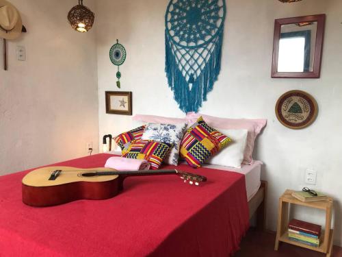 a bedroom with a guitar on a bed at Canto Alegre Pernambuco in Goiana