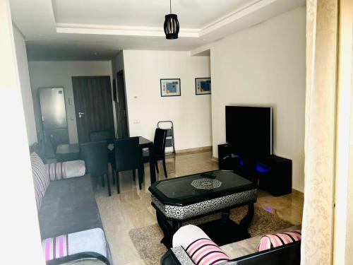 ein Wohnzimmer mit Sofa und Tisch in der Unterkunft Taj 3 in Nouaceur