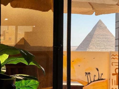 a window with a view of the pyramids at Pyramids View Rooftop Apartment in Ghaţāţī