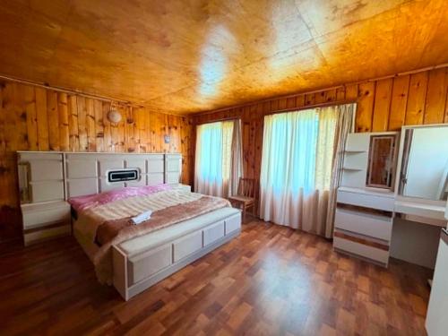 a bedroom with a large bed and wooden walls at Guesthouse Tetnuldi in Kʼolashi
