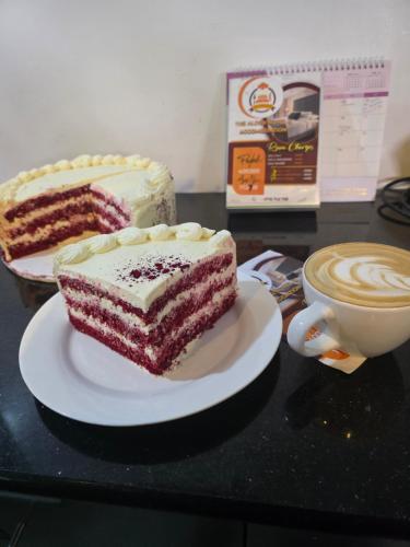 a piece of cake on a table next to a cup of coffee at The alder hotel and accommodation in Bungoma