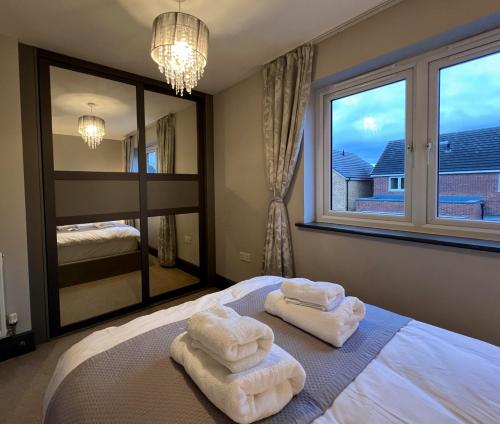 a bedroom with towels on a bed with a large window at Luxury Durham Home, Sleeps up to 12, Free Parking in Durham
