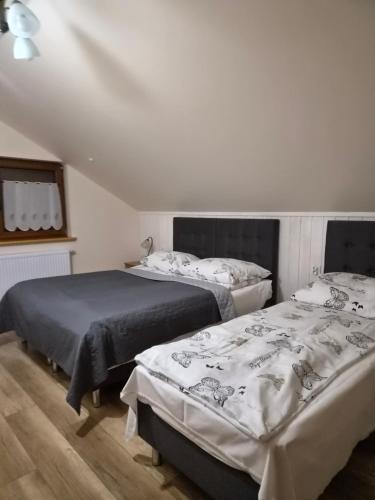 a bedroom with two beds and a window at Domek całoroczny Nad Stawem in Powidz