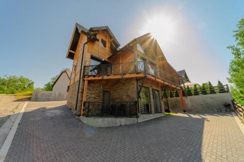 a house with a deck on the side of it at LUX PINE house in Zlatibor
