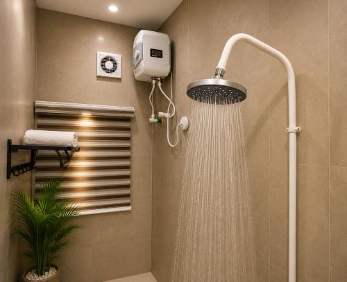 a shower with a shower head in a bathroom at Westside Beach Resort & Hotel in Mopo Akinlade