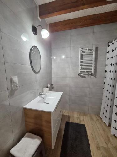 a bathroom with a white sink and a mirror at Domek całoroczny Nad Stawem in Powidz