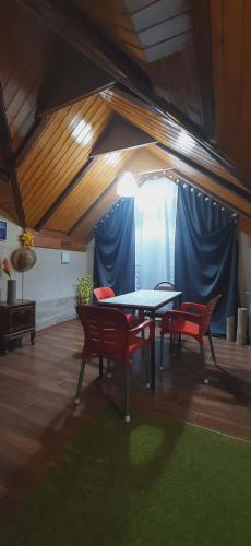 a dining room with a table and two red chairs at Captain in Ureki
