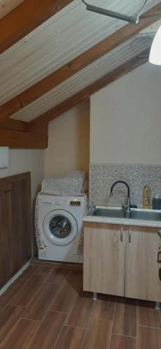 a kitchen with a sink and a washing machine at Captain in Ureki