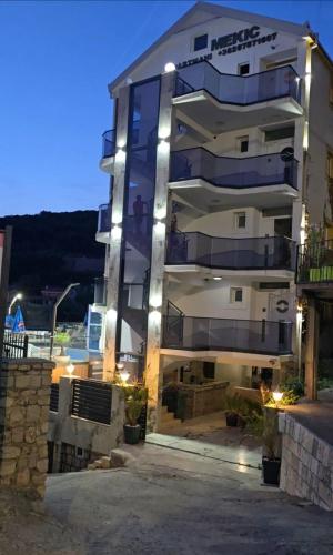 a large building with lights in front of it at Apartments Mekic in Utjeha