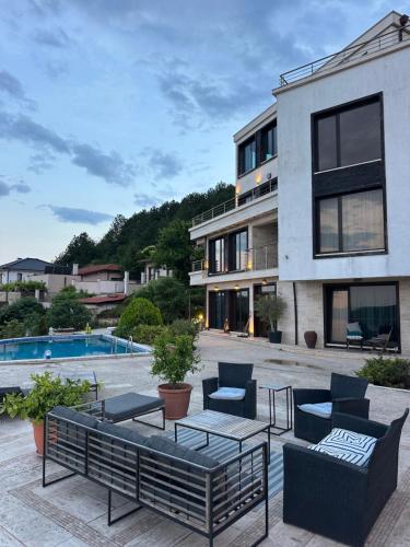 a patio with chairs and tables and a building at The Shefers Residence in Rogachevo