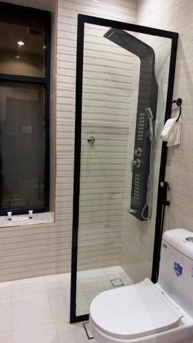 a shower in a bathroom with a toilet and a phone at فندق أروف Aroov Hotel in Taif