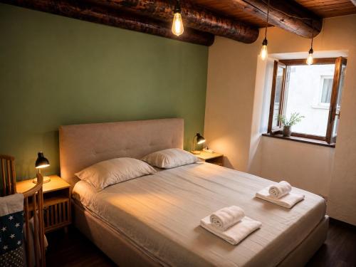 a bedroom with a large bed with towels on it at La Baita Delle Due Valli in Maccagno Superiore