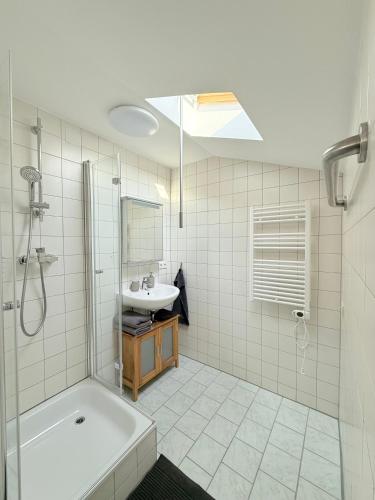 a bathroom with a tub and a sink and a shower at Sleep & Go Höchst in Höchst