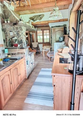 a kitchen with wooden cabinets and a stone wall at Kamienna Polana in Wapienne