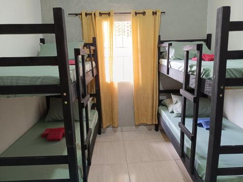 a room with three bunk beds and a window at Casa com churrasqueira – Próx. Shopping Comércios in Várzea Paulista