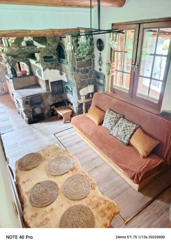 a living room with a couch and a stone fireplace at Kamienna Polana in Wapienne